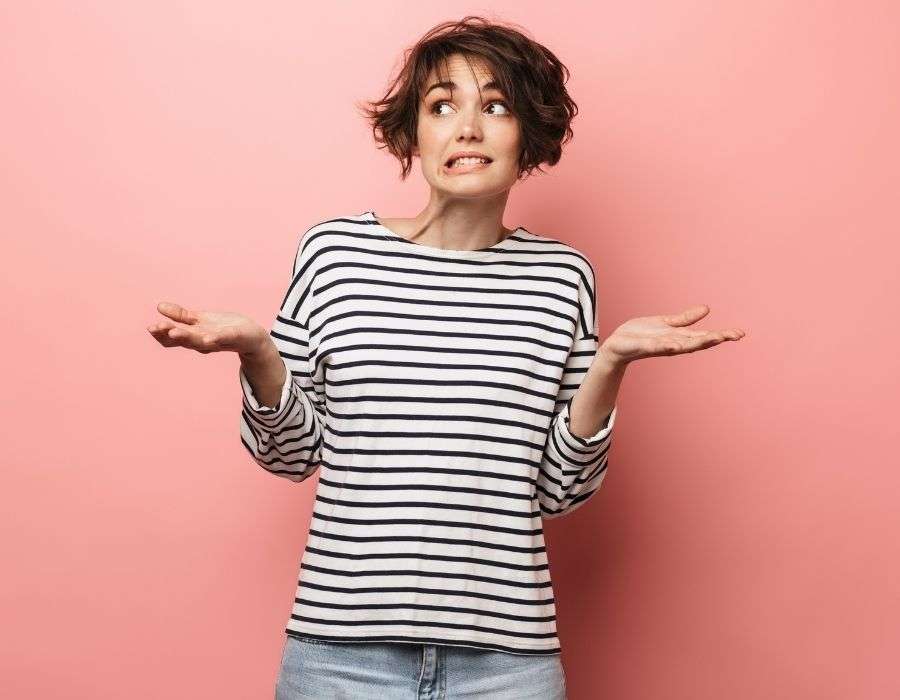 woman-short-curly-dark-hair-hands-up-questioning-expression-striped-shirt-question-everything-blog-post