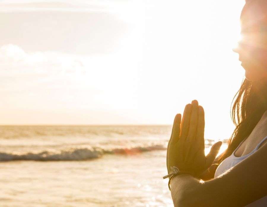 beach-sunset-woman-holding-meditation-pose
