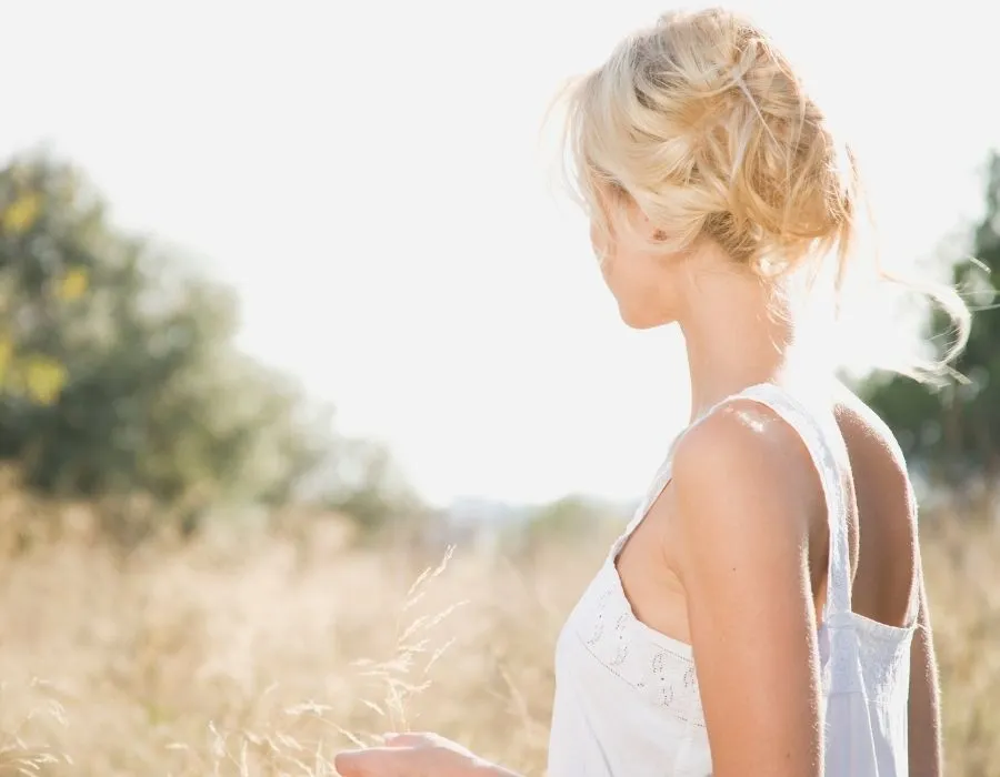 woman-from-behind-in-grass-field-white-shirt-blonde-hair-stronger-than-you-think-blog-post