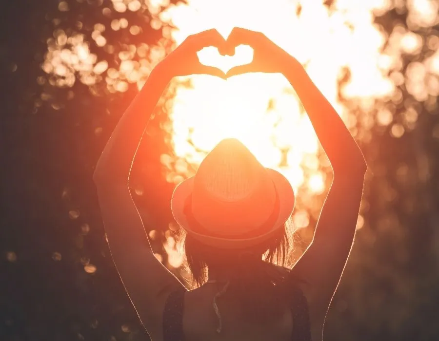 woman-straw-hat-arms-reaching-up-making-heart-with-hands-silhouette-against-the-sun-intuition-talking-to-you-blog-post