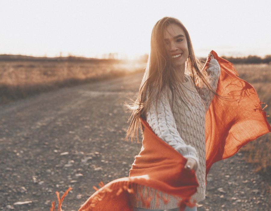 happy-woman-on-roadside-swirling-scarf-daily-self-care-blog